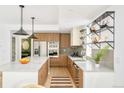 Modern kitchen features stainless steel appliances, wood cabinets, island, and open shelving at 2736 N Clay St, Denver, CO 80211