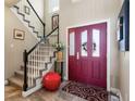 Foyer with a view of the staircase and a striking red front door at 8559 W 93Rd W Ct, Broomfield, CO 80021