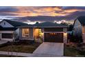 Charming single-Gathering home featuring stone accents and a well-manicured lawn at dusk at 5211 Routt Ct, Arvada, CO 80002