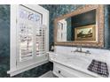 Stylish powder room features decorative wallpaper, a marble vanity top, and elegant fixtures at 930 E 7Th Ave, Denver, CO 80218