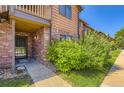 Charming townhouse exterior with brick facade, private entrance and mature landscaping at 2223 S Buckley Rd # 102, Aurora, CO 80013