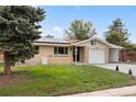 Front view of a ranch home with solar panels, landscaping, and a carport at 5329 Flower Cir, Arvada, CO 80002