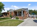 Lovely home with a well-manicured lawn, brick facade, and inviting front porch at 2430 S Ogden St, Denver, CO 80210
