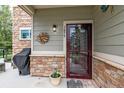 Townhome's front door with a storm door and welcome mat at 1879 S Buchanan Cir, Aurora, CO 80018