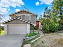 Charming exterior with front door, nicely landscaped yard, and an attached garage at 12798 Tomahawk Rd, Parker, CO 80138
