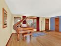 Traditional living room featuring a piano, hardwood floors, and large windows at 12798 Tomahawk Rd, Parker, CO 80138