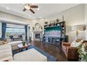 Spacious living room featuring a fireplace, ceiling fan, hardwood floors, and large window with stunning views at 27423 E Euclid Dr, Aurora, CO 80016