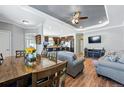 Inviting living area flows into kitchen, featuring wood floors, a breakfast bar, and modern decor at 6231 Indian Paintbrush St # 214, Frederick, CO 80530