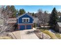 Charming two-story home featuring a brick and blue-sided facade, two-car garage, and mature landscaping at 7464 Shoreham Pl, Castle Pines, CO 80108