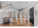 Grand foyer with hardwood floors, a modern staircase, and an arched doorway to a study at 6132 S Boston Cir, Englewood, CO 80111