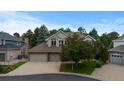 Charming two-story home with a brick facade, mature trees, a two car garage, and a well-manicured lawn at 6132 S Boston Cir, Greenwood Village, CO 80111