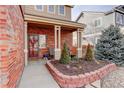 Inviting front porch featuring brick accents, neutral paint, and decorative landscaping at 11701 Elkhart St, Commerce City, CO 80603