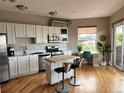Charming kitchen with stainless steel appliances, white cabinets, and a central island with bar seating at 1441 Central # 305, Denver, CO 80211