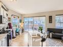 Open-concept living area leading to a private balcony, featuring hardwood floors and contemporary decor at 1441 Central # 305, Denver, CO 80211