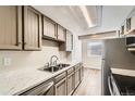 Bright kitchen features stainless steel appliances, a double sink, and white counter tops at 8717 Carr Loop, Arvada, CO 80005