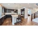 Modern kitchen featuring a large island, granite countertops, dark wood cabinets, and stainless steel appliances at 12578 Hudson Ct, Thornton, CO 80241