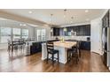 Modern kitchen featuring a large island, granite countertops, dark wood cabinets, and stainless steel appliances at 12578 Hudson Ct, Thornton, CO 80241