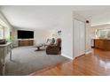 Spacious living room featuring hardwood floors, cozy carpet, and a large entertainment center at 1866 Mountain View St, Erie, CO 80516