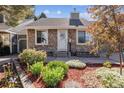 Charming home featuring stone siding, a landscaped yard with rock and wood details, and a white front door at 4720 S Dudley St # 38, Littleton, CO 80123