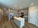 Modern kitchen with island, stainless steel appliances, and light gray cabinets at 9444 Yampa St, Commerce City, CO 80022