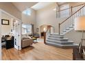 Bright living room showcasing high ceilings, hardwood floors, and a staircase at 420 Graham Cir, Erie, CO 80516