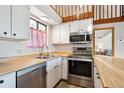 Galley kitchen with stainless steel appliances, light countertops, and a window over the sink at 5250 S Huron Way # 5-308, Littleton, CO 80120