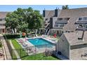 Community outdoor pool with lounge chairs and umbrellas with a view of the community townhomes at 5250 S Huron Way # 5-308, Littleton, CO 80120