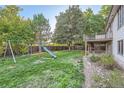 Large backyard features a lush lawn, mature trees, and a fun playset for  at 9670 W 69Th Ave, Arvada, CO 80004