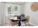 Cozy dining area featuring wood table, modern decor, large window, and natural lighting at 13051 W Jewell Cir, Lakewood, CO 80228