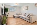 Light-filled living room featuring a sectional sofa and wood floors at 3720 S Hazel Ct, Englewood, CO 80110