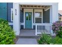Inviting front porch with blue door, white trim, and attractive landscaping at 658 Casper Dr, Lafayette, CO 80026