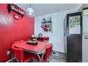 Cozy dining area with a retro red table, chairs, and vintage decor against a vibrant red wall at 10785 W 63Rd Pl # 202, Arvada, CO 80004