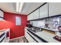 Efficient kitchen with white cabinets, laminate floors, and stainless steel sink and appliances at 10785 W 63Rd Pl # 202, Arvada, CO 80004