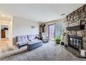 Comfortable living room with a stone fireplace, plush seating, and a sliding glass door at 10785 W 63Rd Pl # 202, Arvada, CO 80004