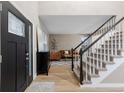 Inviting foyer showcasing staircase, neutral walls, light wood floors, and black accents at 18233 E Dorado Ave, Centennial, CO 80015