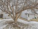 Charming two-story home with light blue siding, a two-car garage, and mature trees in the front yard at 3833 S Bahama St, Aurora, CO 80013