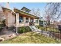 Side view of a home with a well-manicured lawn, black iron fence, and inviting front porch with space for relaxing at 438 S Emerson St, Denver, CO 80209
