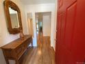 Inviting entryway featuring hardwood floors, a decorative mirror, and a bold red door at 540 S Forest St # A2, Denver, CO 80246