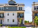 Attractive three-story home featuring a covered balcony, modern design, and fresh landscaping at 6162 W 28Th Ct, Edgewater, CO 80214