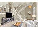Bright living room featuring an open staircase, neutral decor, and modern furnishings at 3720 Pecos Trl, Castle Rock, CO 80109