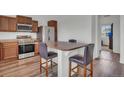 Eat-in kitchen features stainless steel appliances, granite countertops, and stylish seating area with barstool seating at 5571 Killarney St, Denver, CO 80249