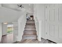 Bright staircase with wood steps and white railings leading to upper level with natural light coming through window at 5571 Killarney St, Denver, CO 80249