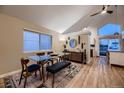 Open concept dining area with hardwood floors, glass table, and mid-century modern decor at 2697 S Deframe Cir, Lakewood, CO 80228
