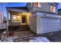 House exterior showcasing front entrance, deck, and attached garage at dusk at 2697 S Deframe Cir, Lakewood, CO 80228