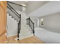 Elegant foyer featuring a staircase with black iron railings and hardwood floors at 2316 Weatherstone Cir, Highlands Ranch, CO 80126