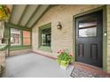 Inviting covered porch featuring exposed brick and cozy space for outdoor decor at 3055 N York St, Denver, CO 80205