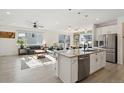 Modern kitchen featuring stainless steel appliances, granite countertops, an island, and seamless flow into the living area at 1030 W Hopkins Dr, Elizabeth, CO 80107