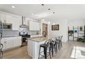 Modern kitchen featuring granite countertops, stainless steel appliances, and sleek white cabinets at 1030 W Hopkins Dr, Elizabeth, CO 80107