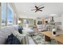 Open-concept living space with modern gray sectional, ceiling fan, and views to dining area and kitchen at 1030 W Hopkins Dr, Elizabeth, CO 80107