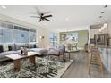 Bright, open living space features a modern ceiling fan, large windows, and a seamless flow to the dining and kitchen areas at 1030 W Hopkins Dr, Elizabeth, CO 80107